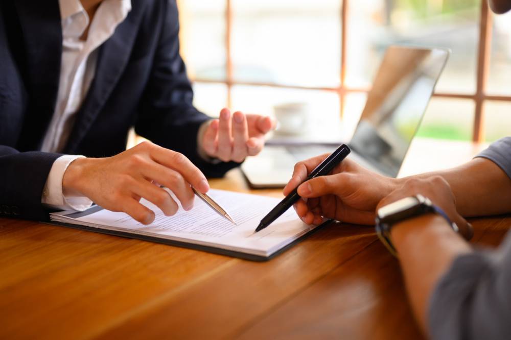 Gros plan sur la signature d'une convention d'honoraires entre un avocat et son client