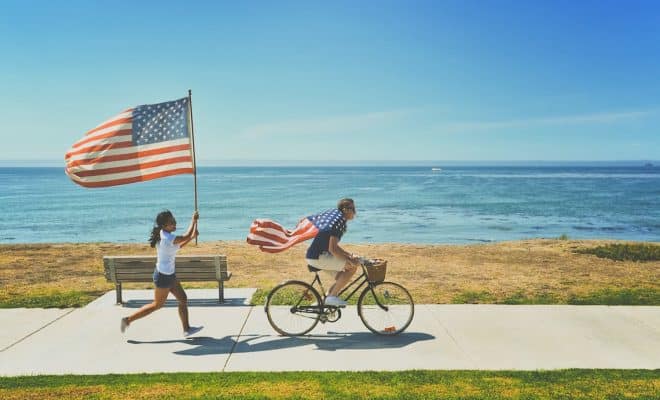 man riding bike and woman running holding flag of USA