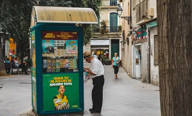 man in white dress shirt and black pants standing beside blue and yellow food stall